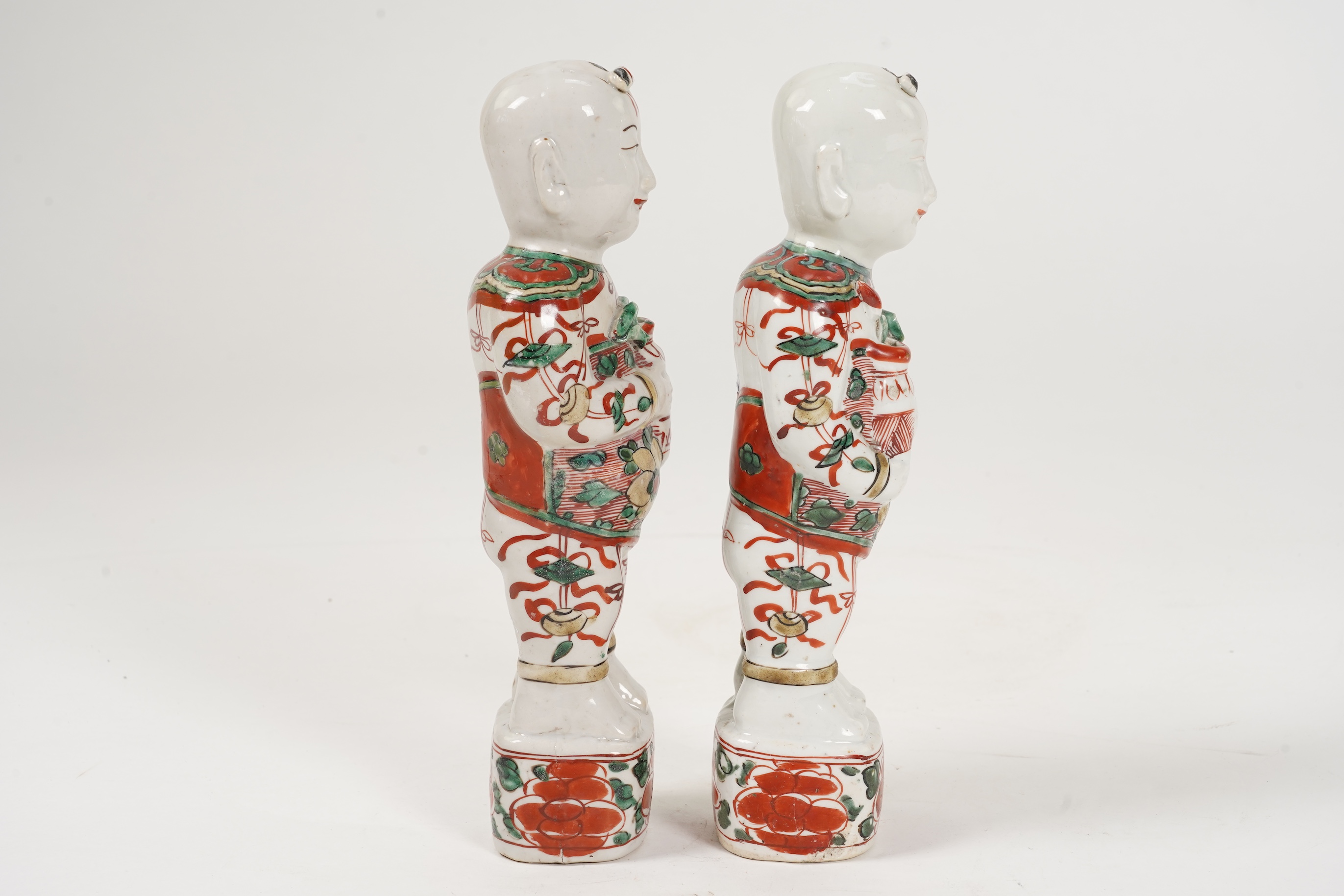 A pair of Chinese famille verte figures of smiling boys, Kangxi period